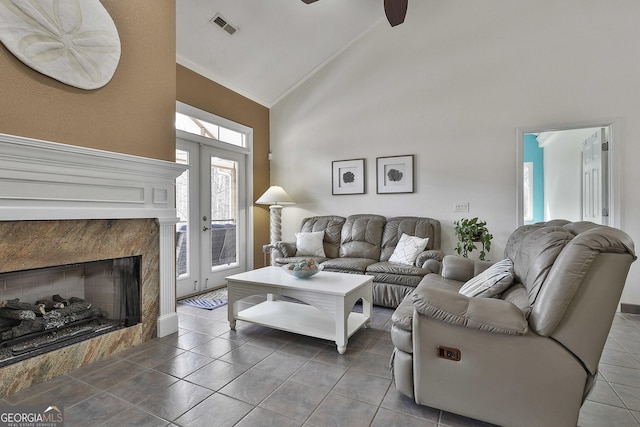 living area featuring ceiling fan, high vaulted ceiling, tile patterned flooring, visible vents, and french doors