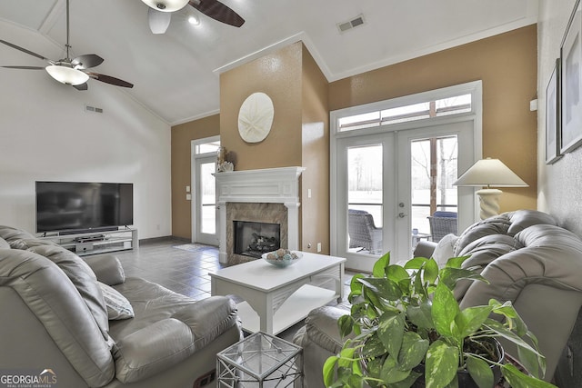 tiled living room featuring french doors, visible vents, and crown molding