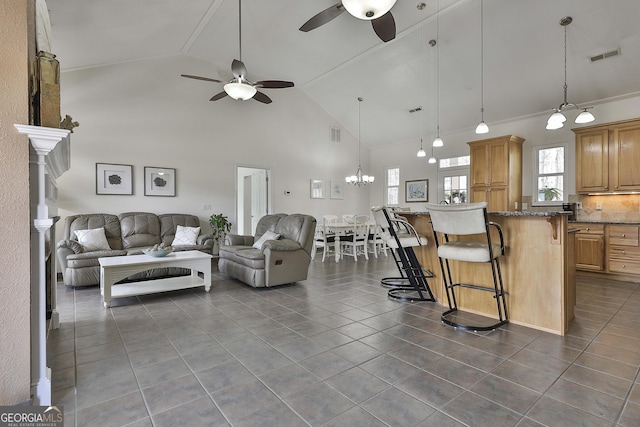 living room featuring high vaulted ceiling, visible vents, dark tile patterned floors, and a ceiling fan