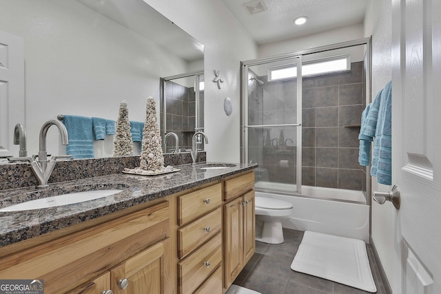 full bathroom featuring double vanity, tile patterned flooring, a sink, and toilet