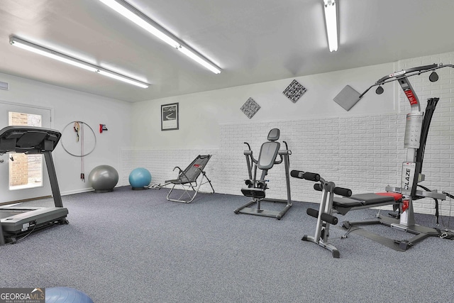 exercise room featuring brick wall