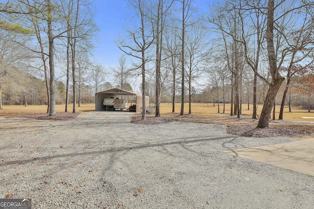 view of yard featuring gravel driveway and a carport