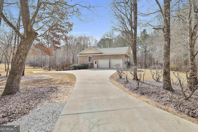 view of side of home featuring concrete driveway, brick siding, and an attached garage