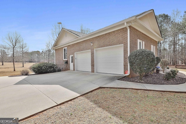 view of property exterior featuring a garage, concrete driveway, and brick siding