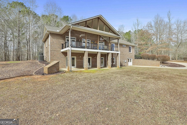 rear view of property with central air condition unit, a yard, a patio, and brick siding