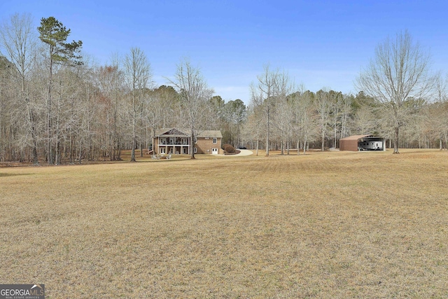 view of yard featuring a forest view and a detached carport