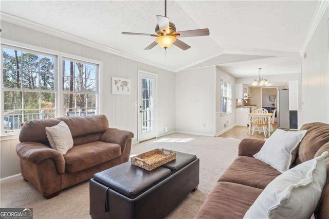 living room featuring crown molding, light carpet, vaulted ceiling, baseboards, and ceiling fan with notable chandelier