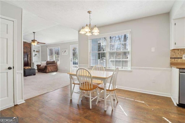 dining room with wood-type flooring, baseboards, a textured ceiling, and ceiling fan with notable chandelier