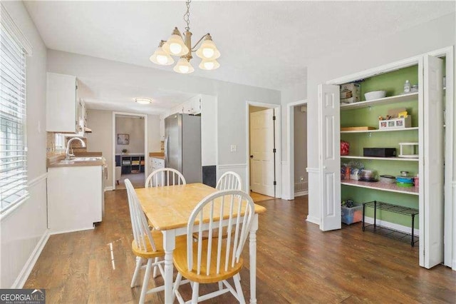 dining room with baseboards, dark wood-type flooring, and a notable chandelier