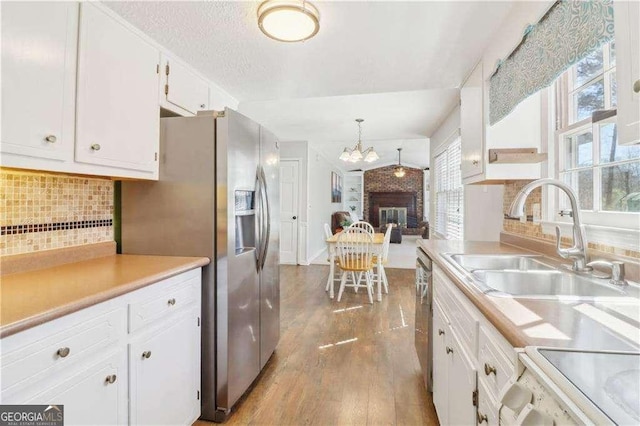 kitchen featuring stainless steel appliances, plenty of natural light, wood finished floors, and white cabinetry