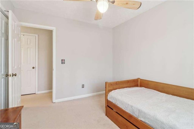 bedroom with light carpet, ceiling fan, and baseboards