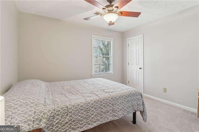 carpeted bedroom featuring ceiling fan and baseboards