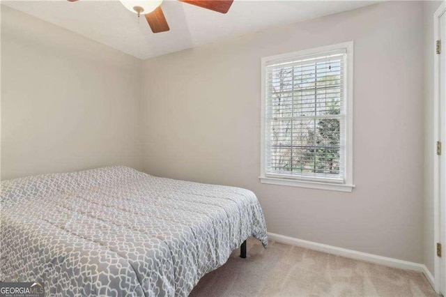 carpeted bedroom with multiple windows, ceiling fan, and baseboards