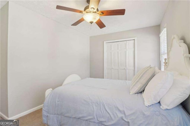 bedroom with carpet floors, a closet, a ceiling fan, and baseboards