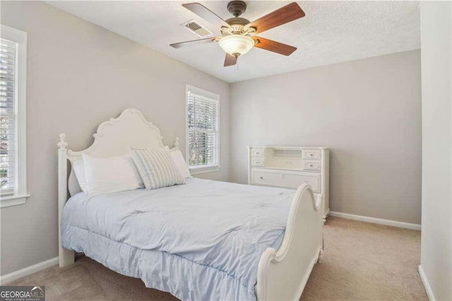 bedroom featuring light carpet, visible vents, and baseboards