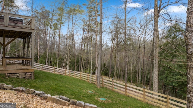 view of yard with fence and a forest view