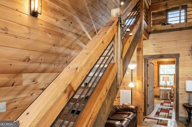 staircase with wood ceiling, visible vents, and wooden walls