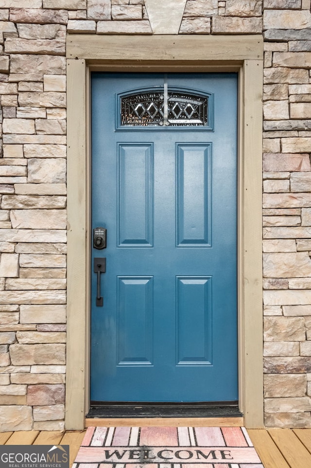 doorway to property featuring stone siding