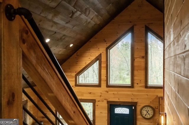 interior space featuring lofted ceiling, wood ceiling, and wood walls