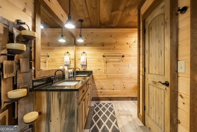 bar featuring wood ceiling, a sink, and wooden walls