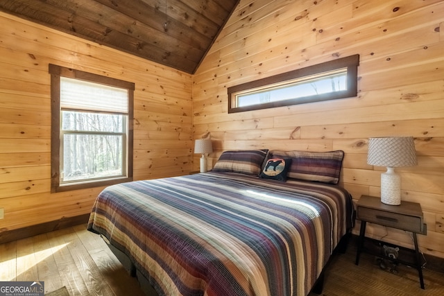 bedroom with lofted ceiling, hardwood / wood-style floors, wooden ceiling, and wooden walls