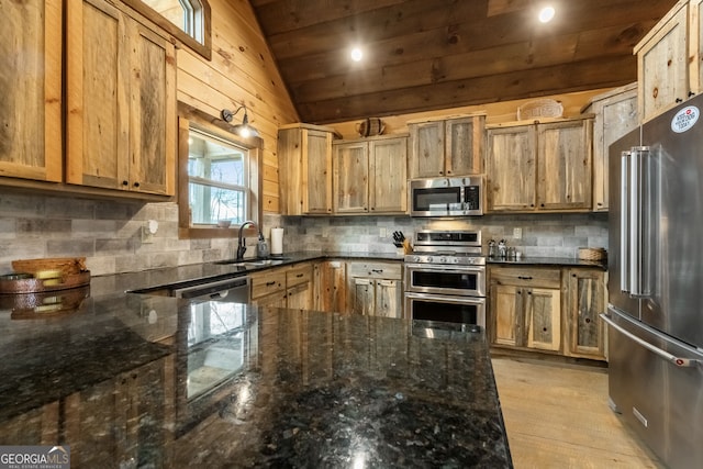 kitchen featuring lofted ceiling, decorative backsplash, stainless steel appliances, and a sink