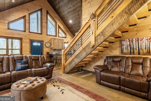 living area featuring stairs, a healthy amount of sunlight, wood walls, wooden ceiling, and hardwood / wood-style flooring