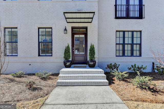 entrance to property featuring brick siding