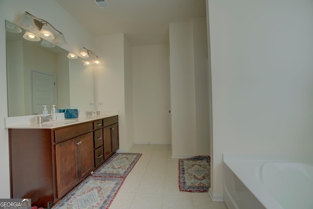 bathroom featuring double vanity, a tub, a sink, and tile patterned floors