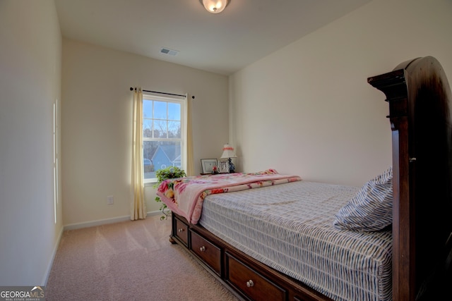 bedroom with baseboards, visible vents, and light colored carpet