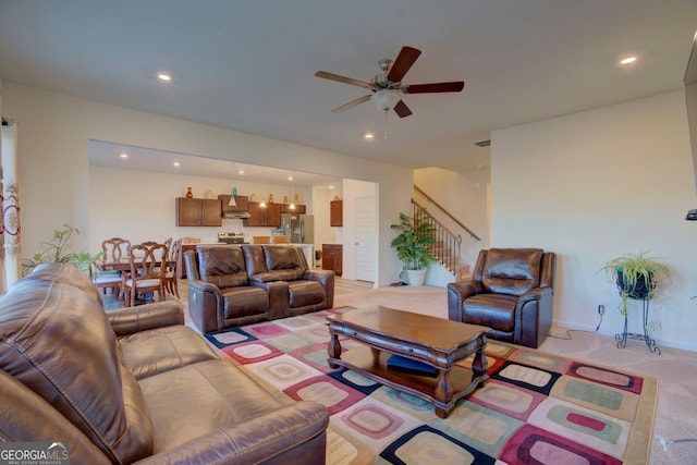 living room featuring ceiling fan, stairway, light colored carpet, and recessed lighting