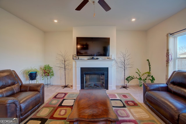 living room featuring carpet, a glass covered fireplace, ceiling fan, and recessed lighting