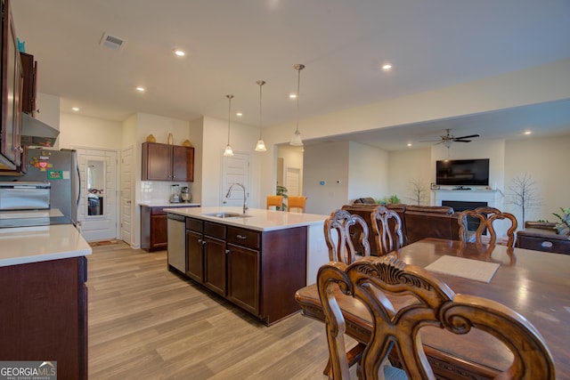 kitchen with light wood finished floors, visible vents, stainless steel appliances, and a sink