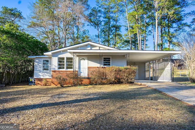 view of front of property with an attached carport, brick siding, and driveway