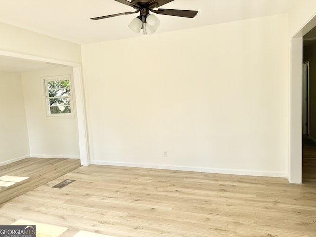 unfurnished room with light wood-type flooring, baseboards, visible vents, and a ceiling fan