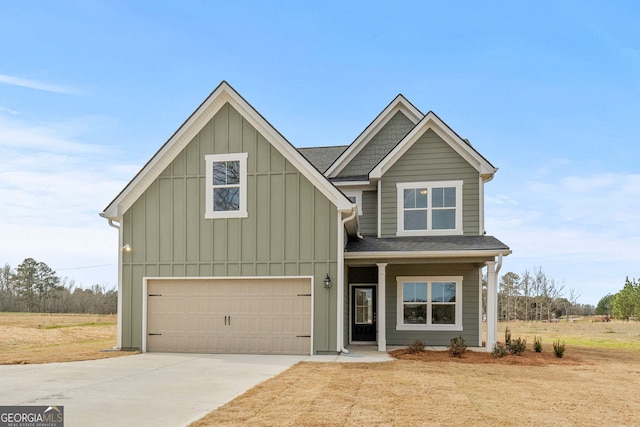 view of front facade with board and batten siding, driveway, a shingled roof, and an attached garage