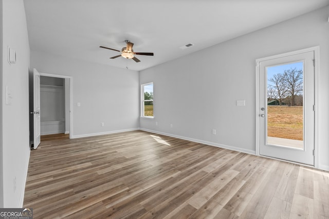 interior space featuring visible vents, wood finished floors, a ceiling fan, and baseboards