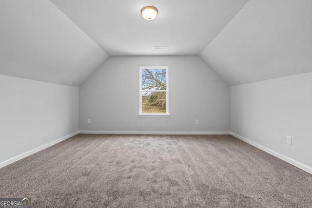 bonus room with carpet floors, visible vents, vaulted ceiling, and baseboards