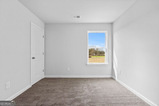 unfurnished room with visible vents, baseboards, and carpet flooring