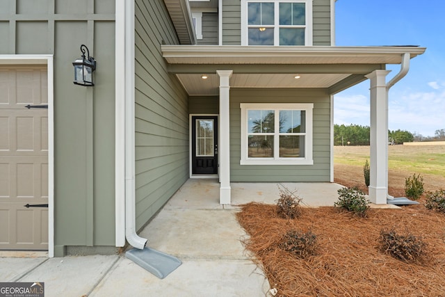 entrance to property with a garage and covered porch