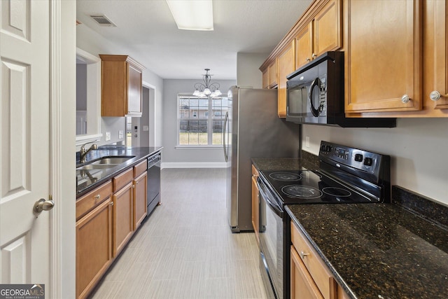 kitchen featuring a sink, visible vents, brown cabinets, black appliances, and an inviting chandelier