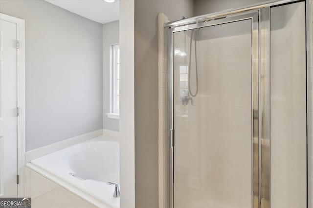 bathroom featuring a stall shower and a bath