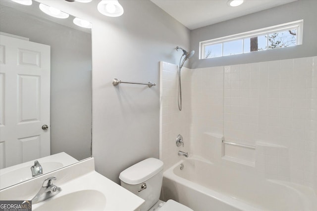 bathroom with tub / shower combination, vanity, and toilet