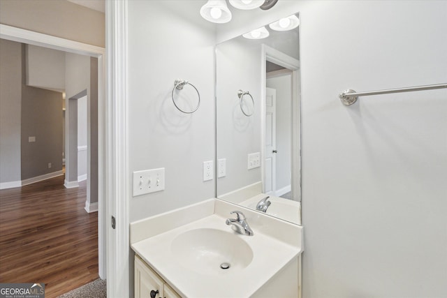 bathroom with baseboards, wood finished floors, and vanity