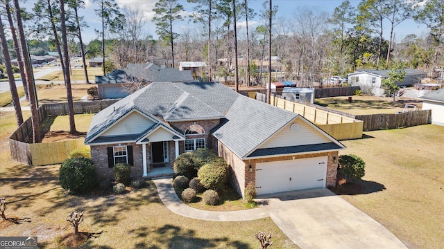 view of front of home with brick siding, a shingled roof, concrete driveway, an attached garage, and fence