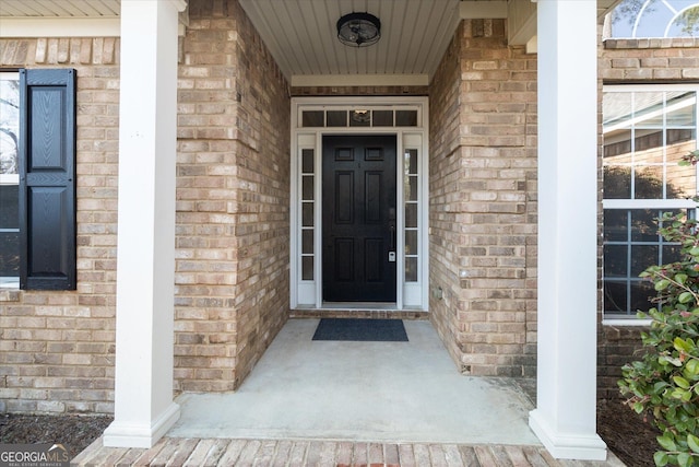 property entrance featuring brick siding