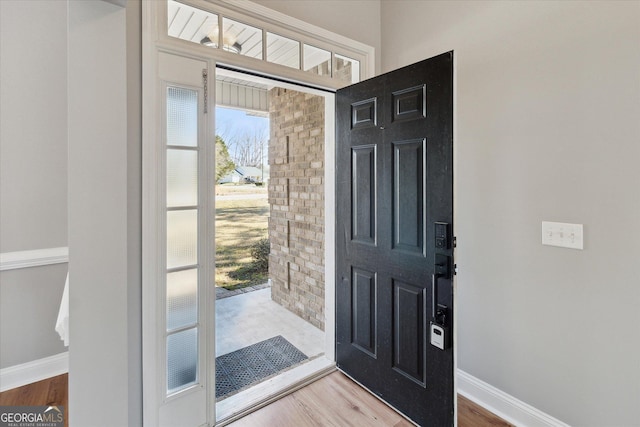 foyer with baseboards and wood finished floors