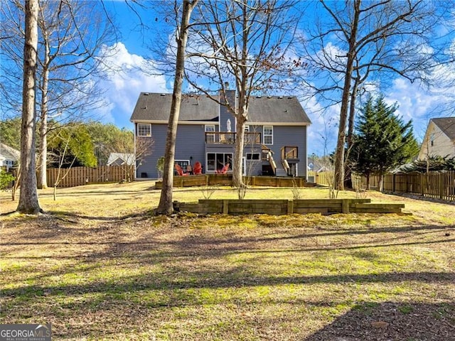 back of property featuring a yard, a fenced backyard, and a wooden deck