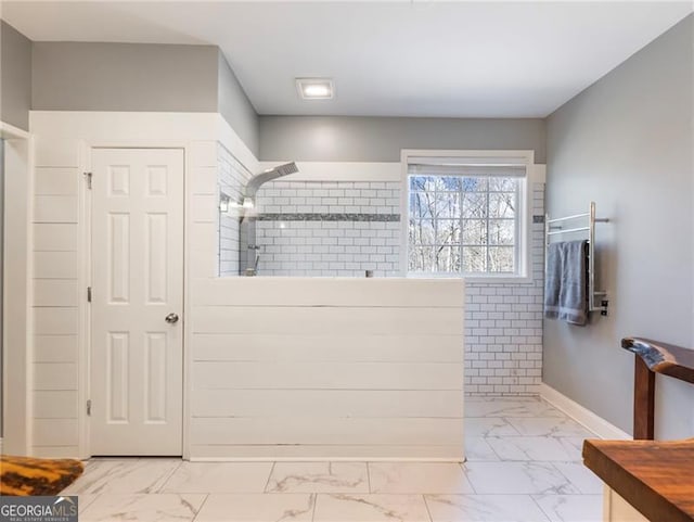 full bathroom with marble finish floor, walk in shower, and baseboards