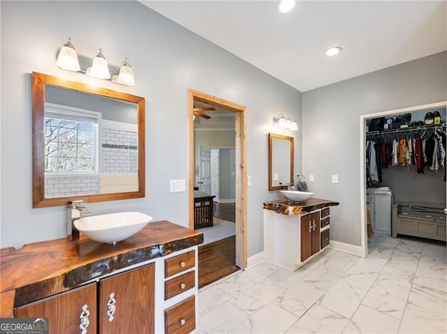 full bath with marble finish floor, two vanities, a sink, and recessed lighting